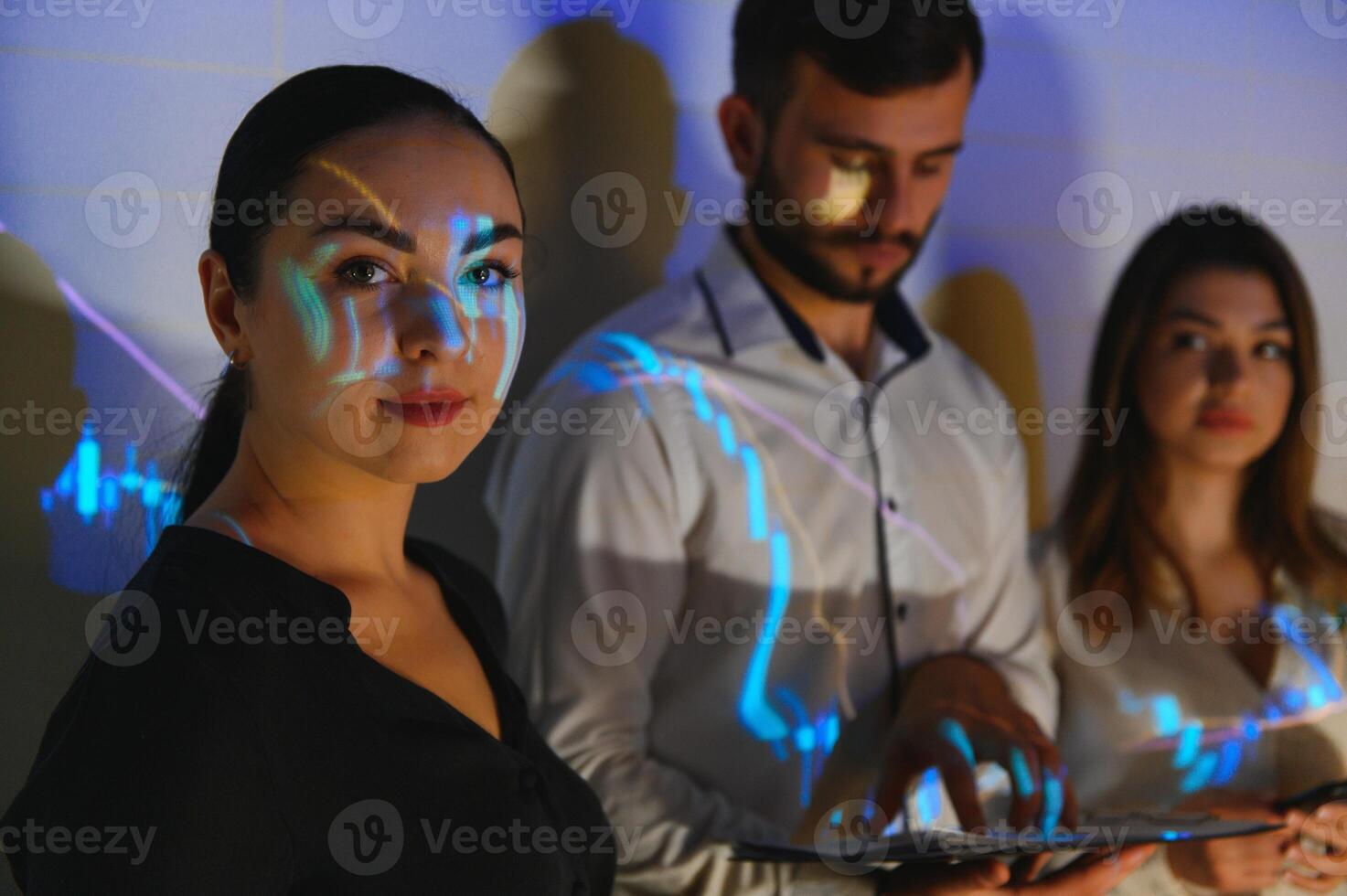 Group of business people working at modern office.Technical price graph, red and blue candlestick chart and stock trading computer screen background. Double exposure. Traders analyzing data photo