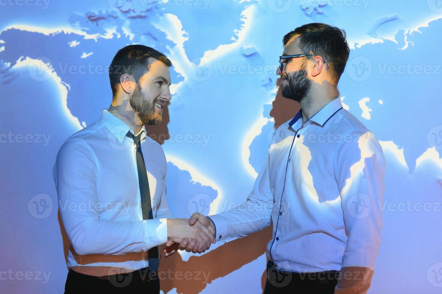 Handshake with map of the world in background photo