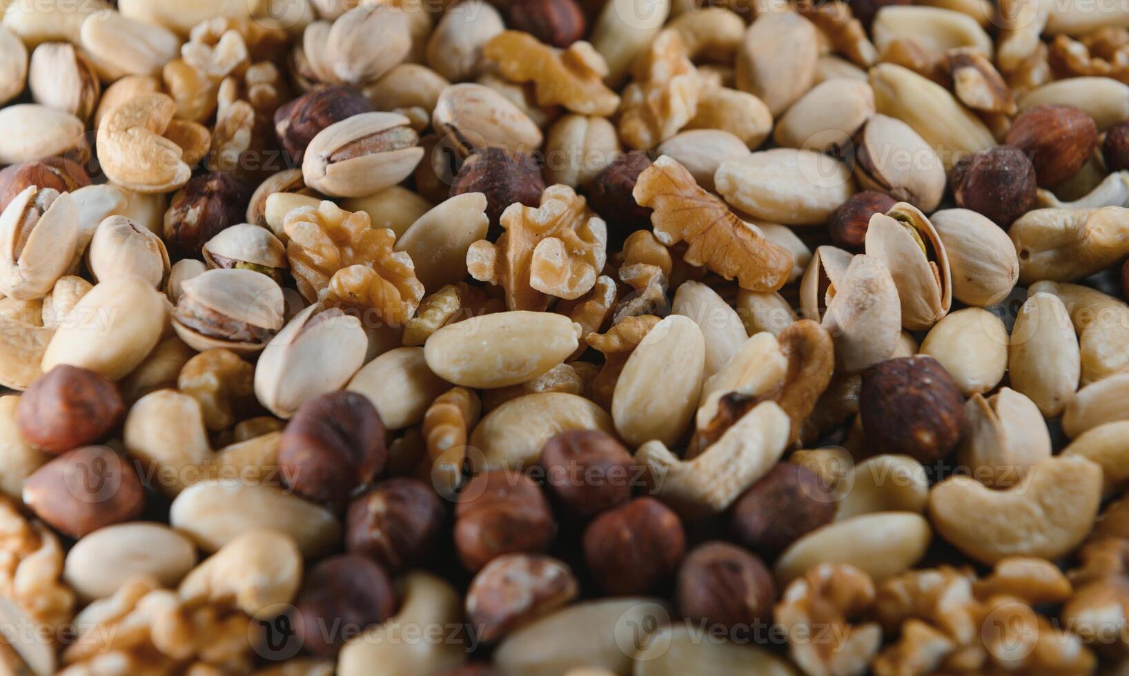 mixed nuts in a bowl on wooden table, top view with copy space. photo