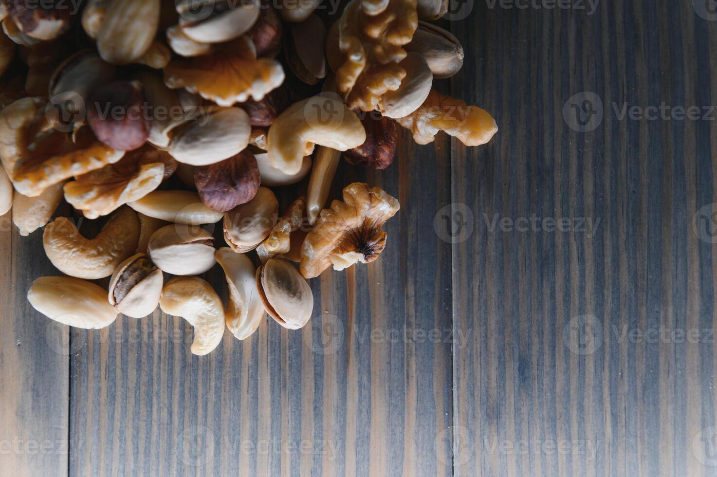 Mixed nuts on wood floor. Organic and fresh nuts. Copy space photo
