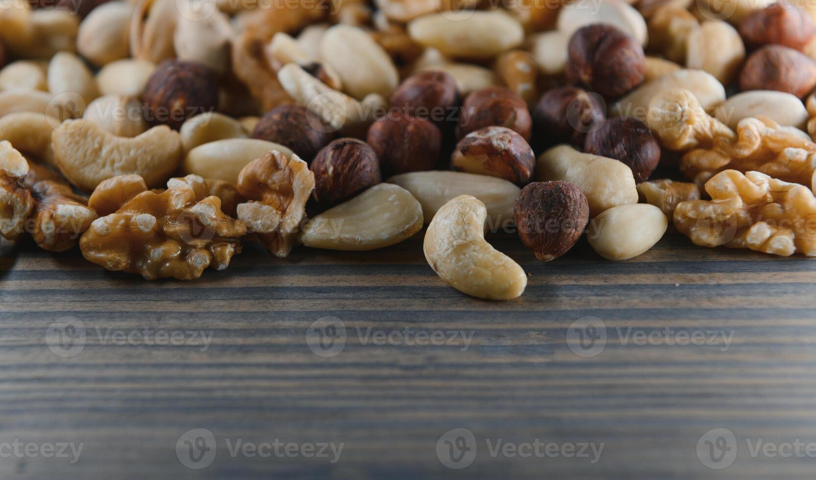 mixed nuts in a bowl on wooden table, top view with copy space. photo