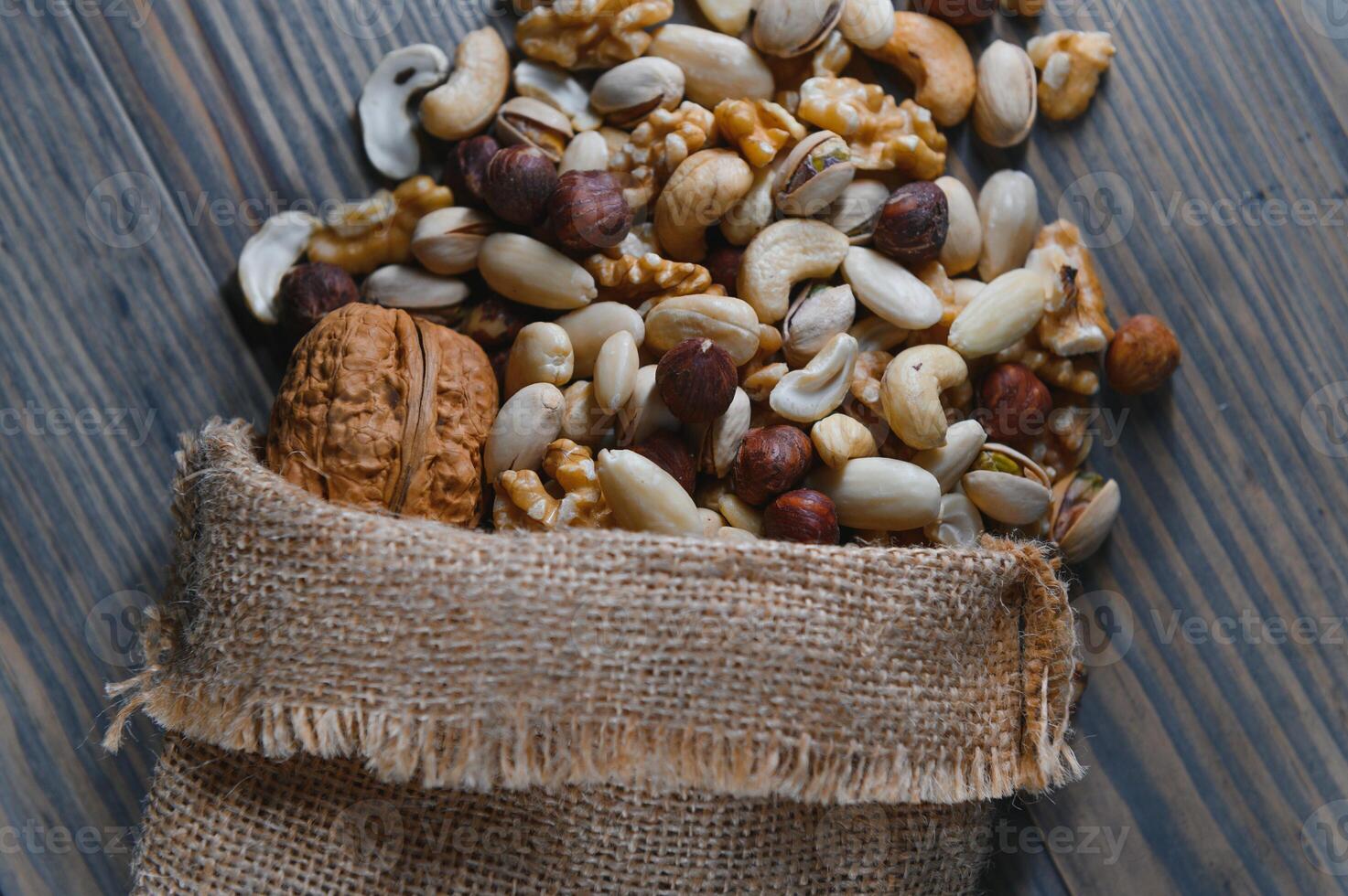 Mixed nuts on wood floor. Organic and fresh nuts. Copy space photo