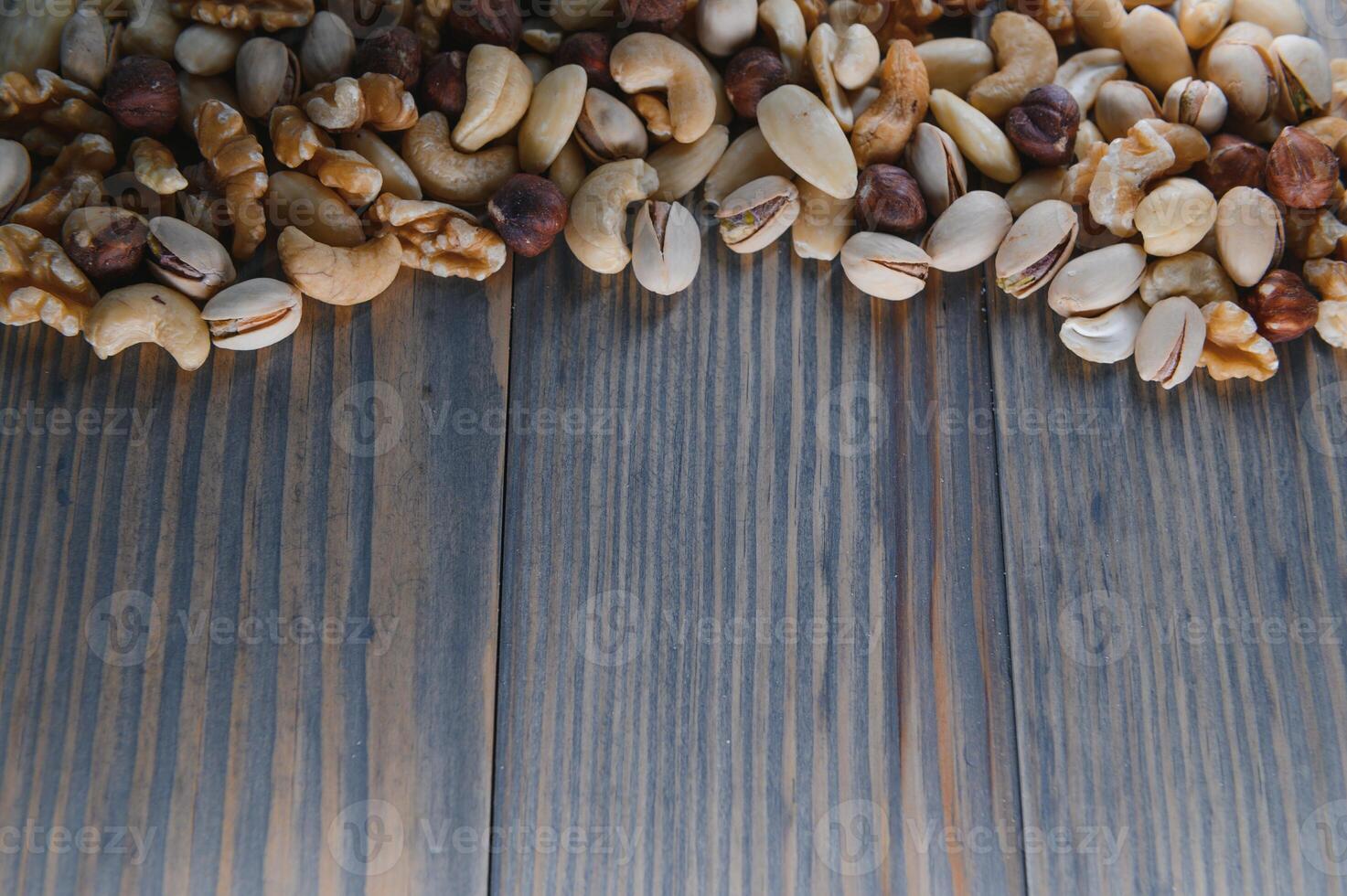 Mixed nuts on wood floor. Organic and fresh nuts. Copy space photo