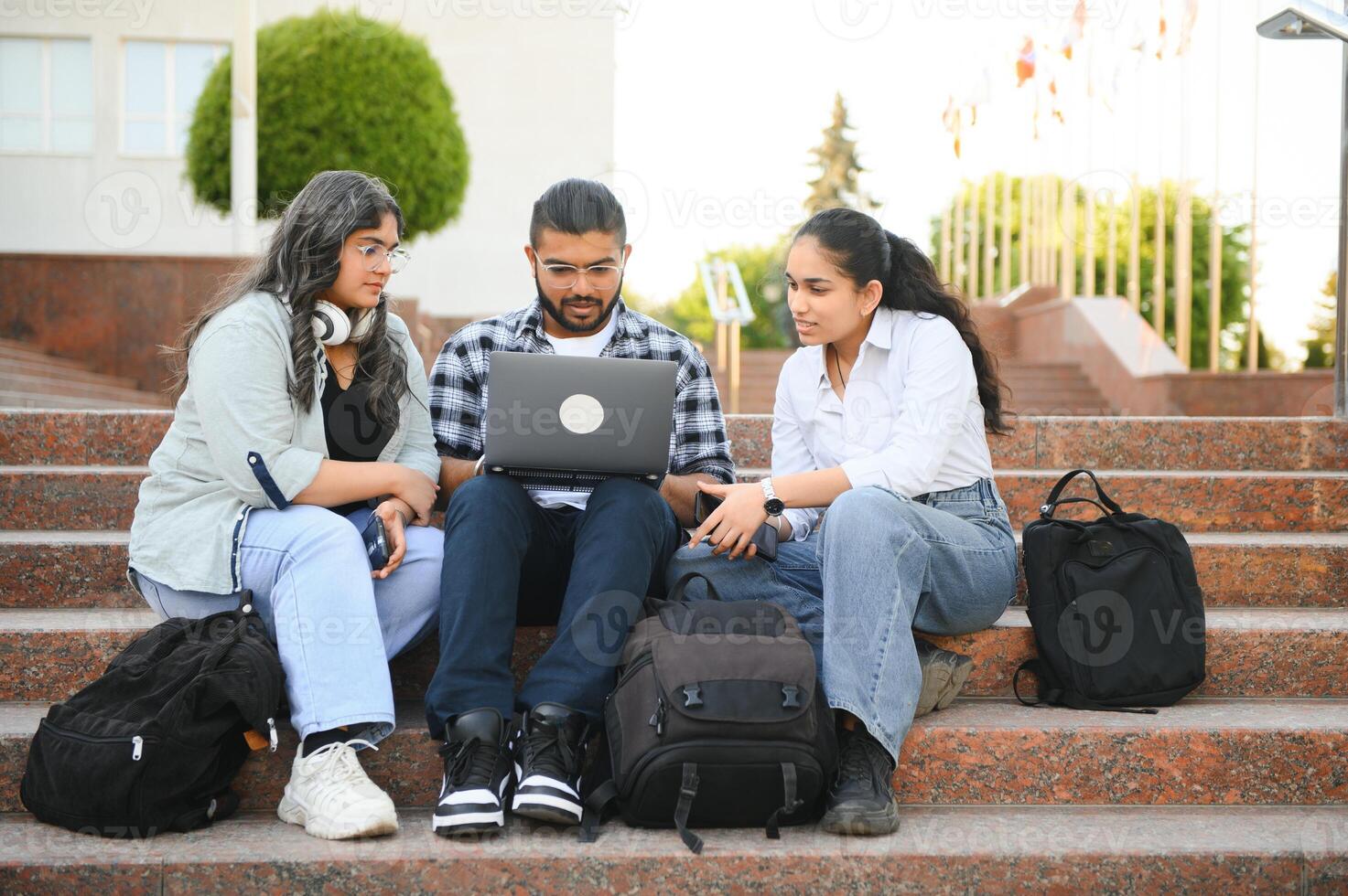 group of young students checking exam results or waiting for project approval on laptop at collage campus photo