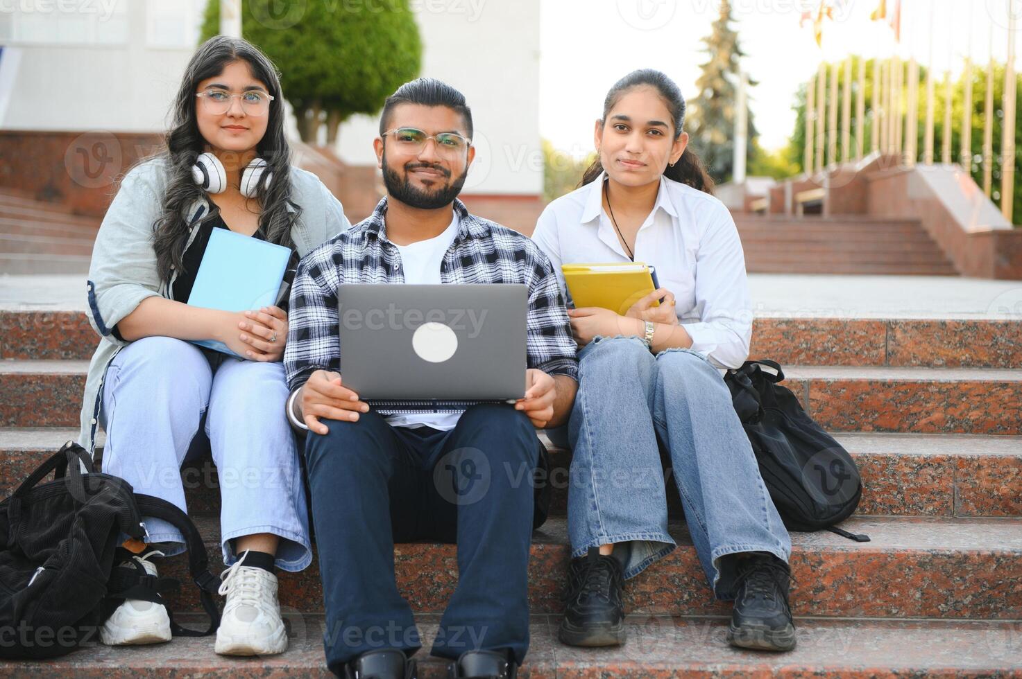 group of young students checking exam results or waiting for project approval on laptop at collage campus photo