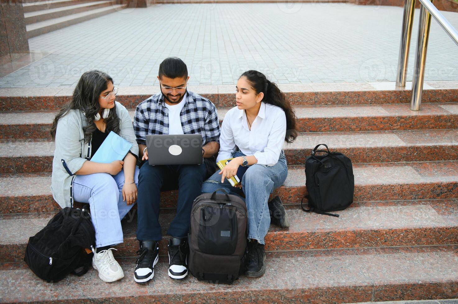 group of young students checking exam results or waiting for project approval on laptop at collage campus photo