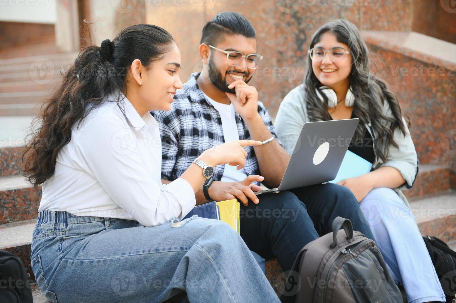 group of young students checking exam results or waiting for project approval on laptop at collage campus photo