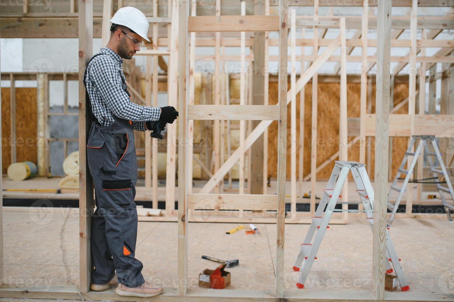 Worker carpenter assembling a modular house photo