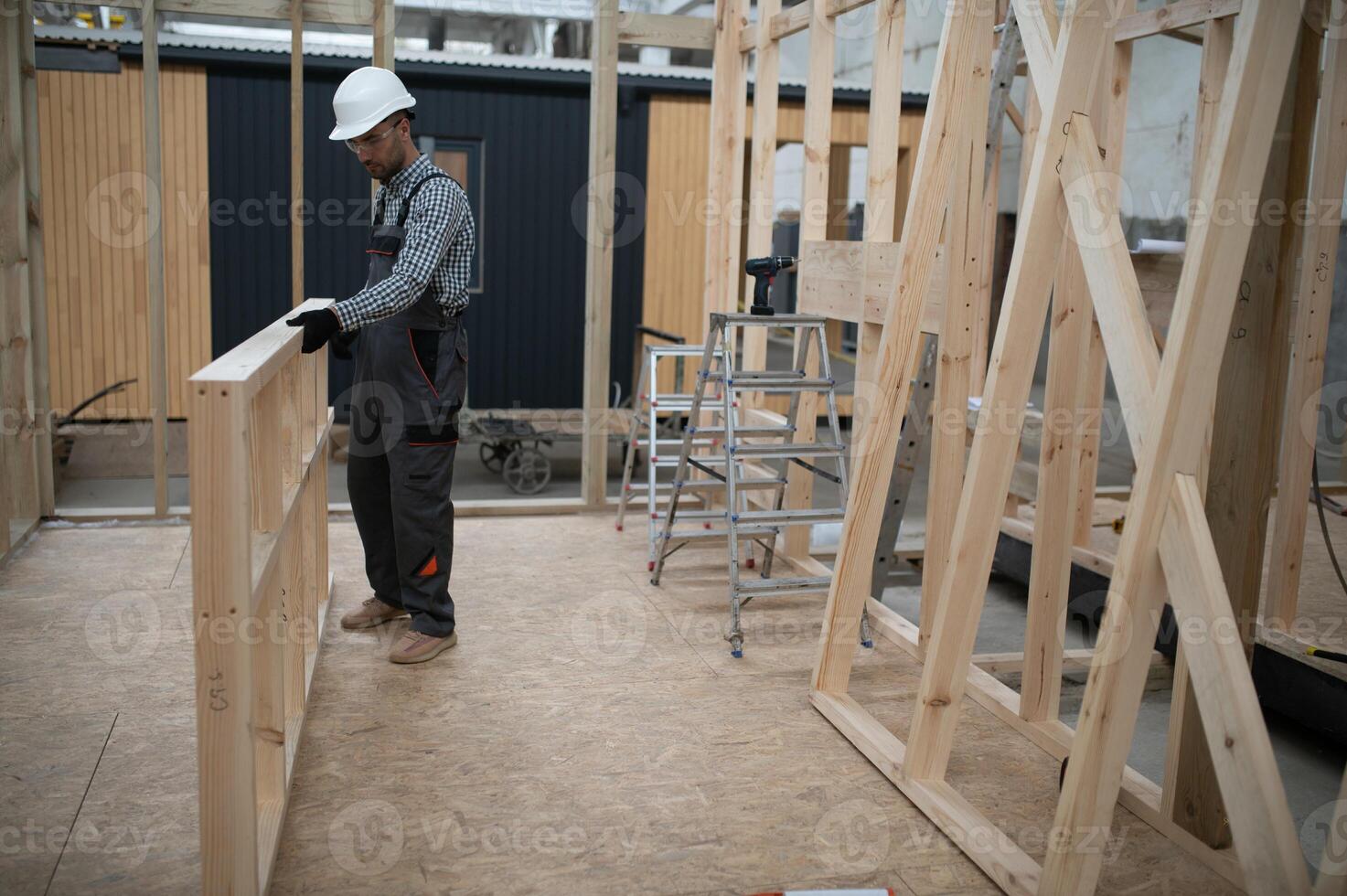 Worker carpenter assembling a modular house photo