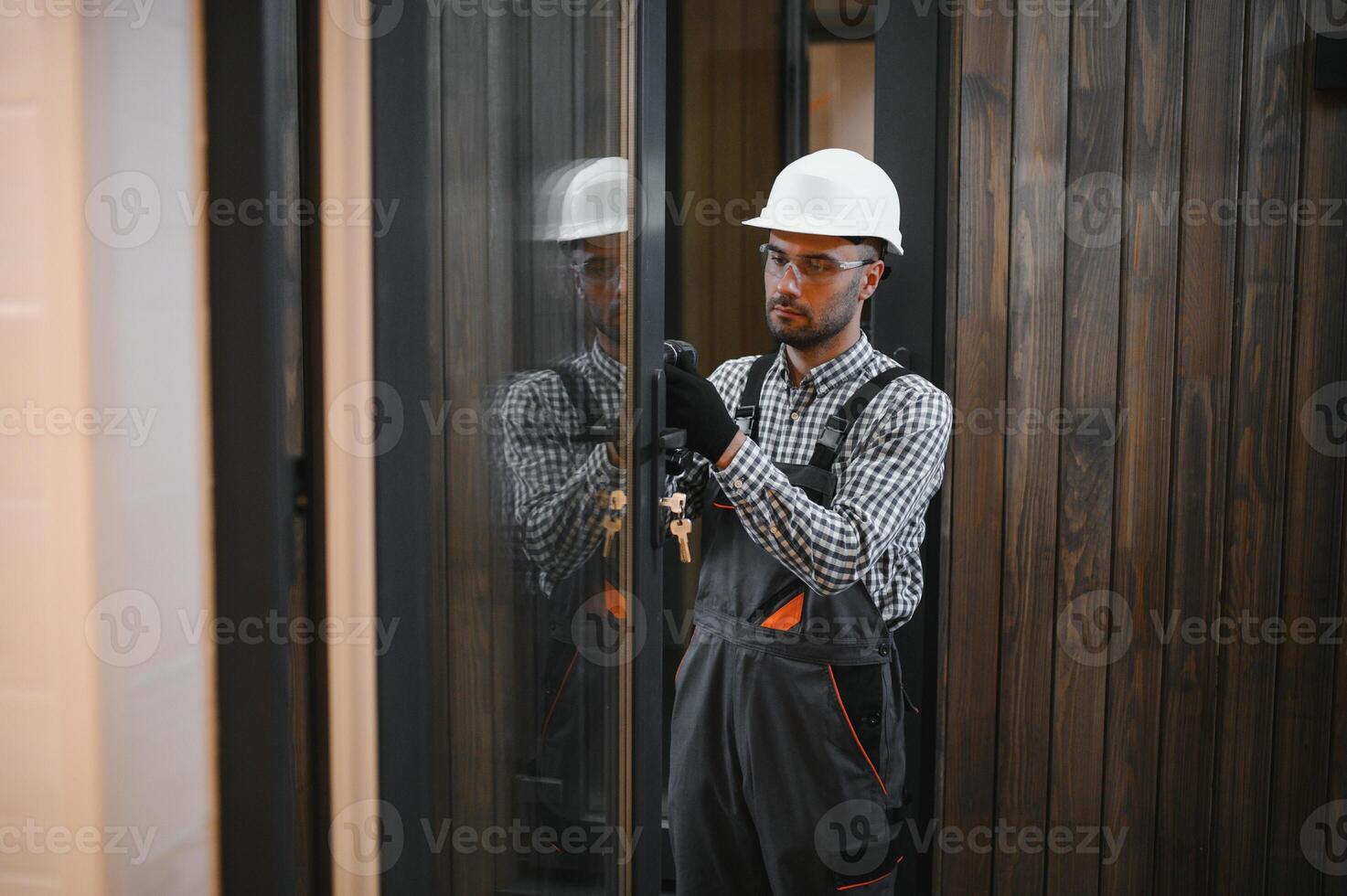 A worker or engineer in a uniform works on a construction site for the manufacture of wooden modular houses photo