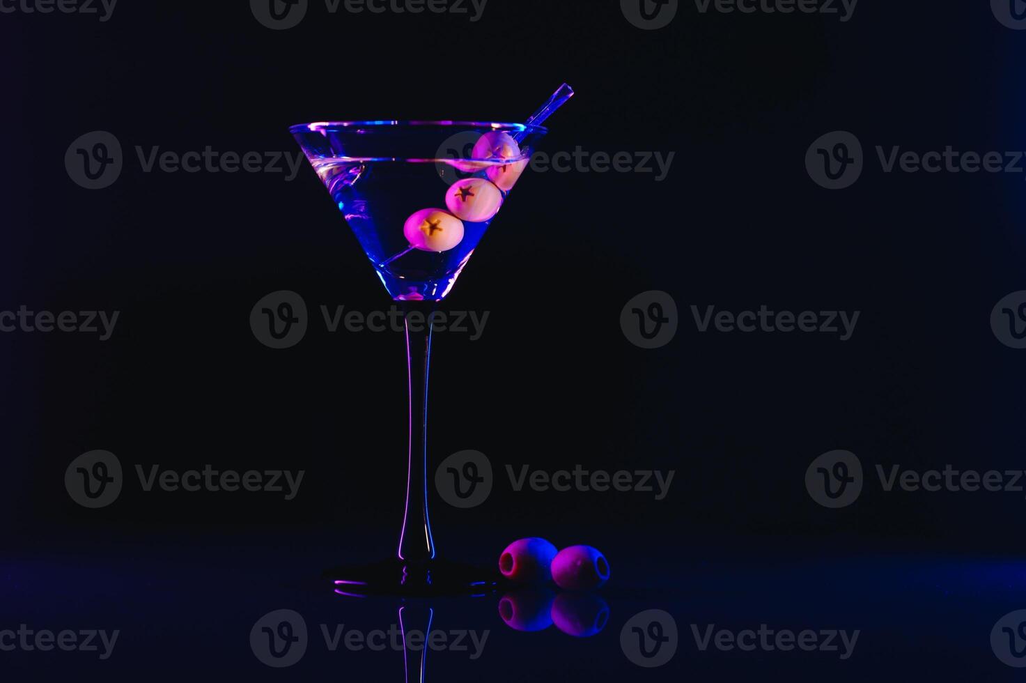 Drink martini. Martini with olives on a black table. Free space for text. photo