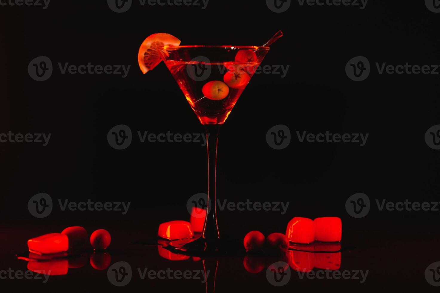 Martini glass and olives on a black background with neon lights photo