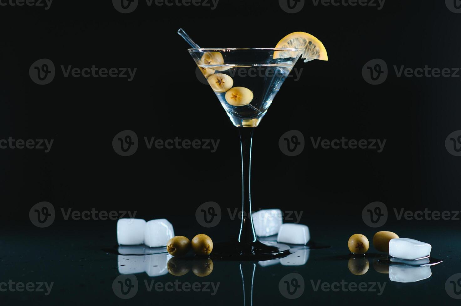 Glass of classic dry martini cocktail with olives on dark table against black background. With free space for your text photo