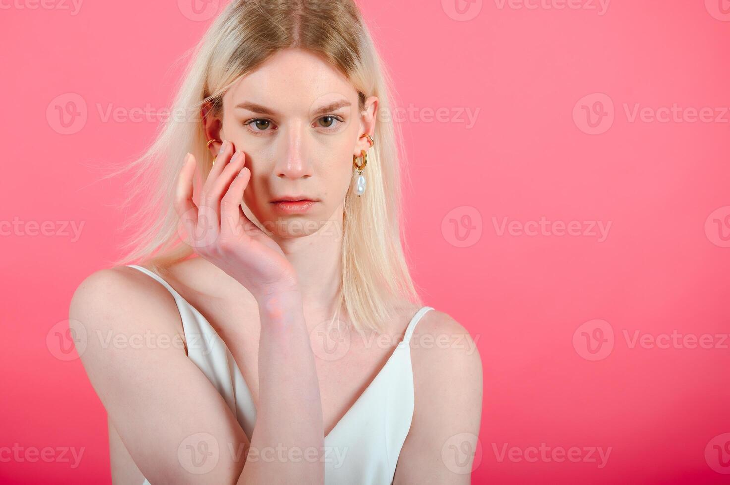 Fashionable young transgender woman on color background photo
