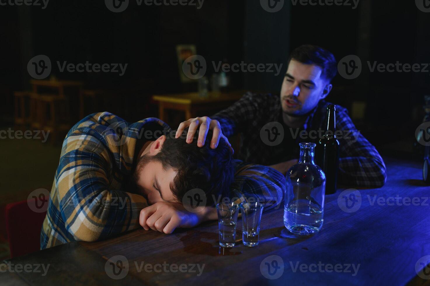 Drunk man sleeps at bar counter, alcohol addiction photo