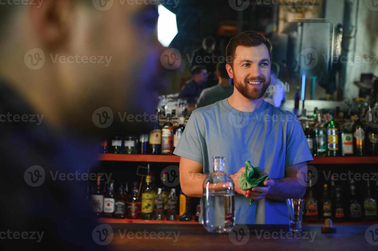 Handsome bar tender standing behind his counter in a pub photo