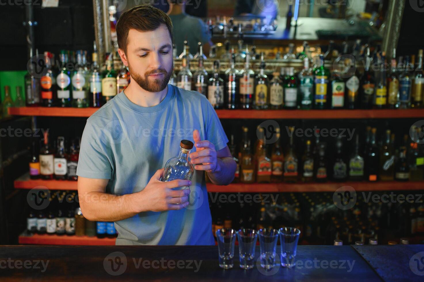Handsome bar tender standing behind his counter in a pub photo
