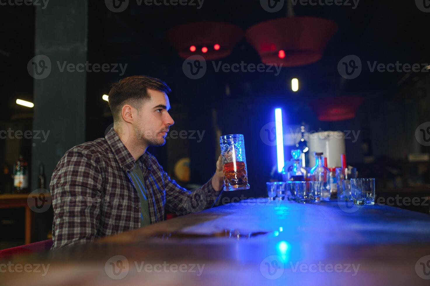 Tasting a good beer. Portrait of thoughtful men drinking beer at the bar photo