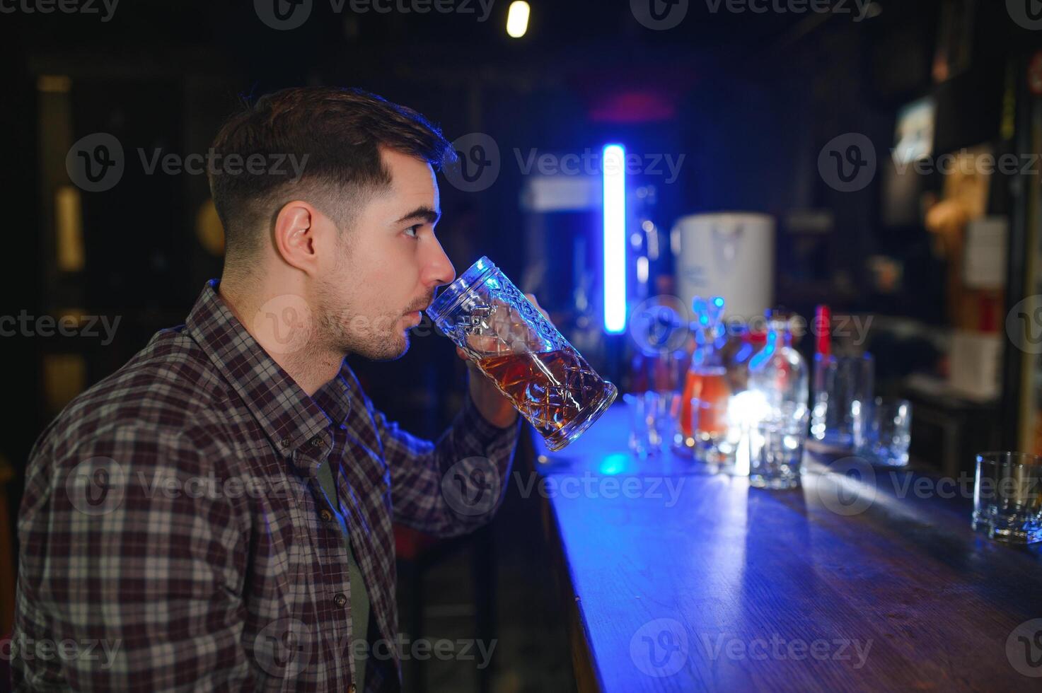 Tasting a good beer. Portrait of thoughtful men drinking beer at the bar photo