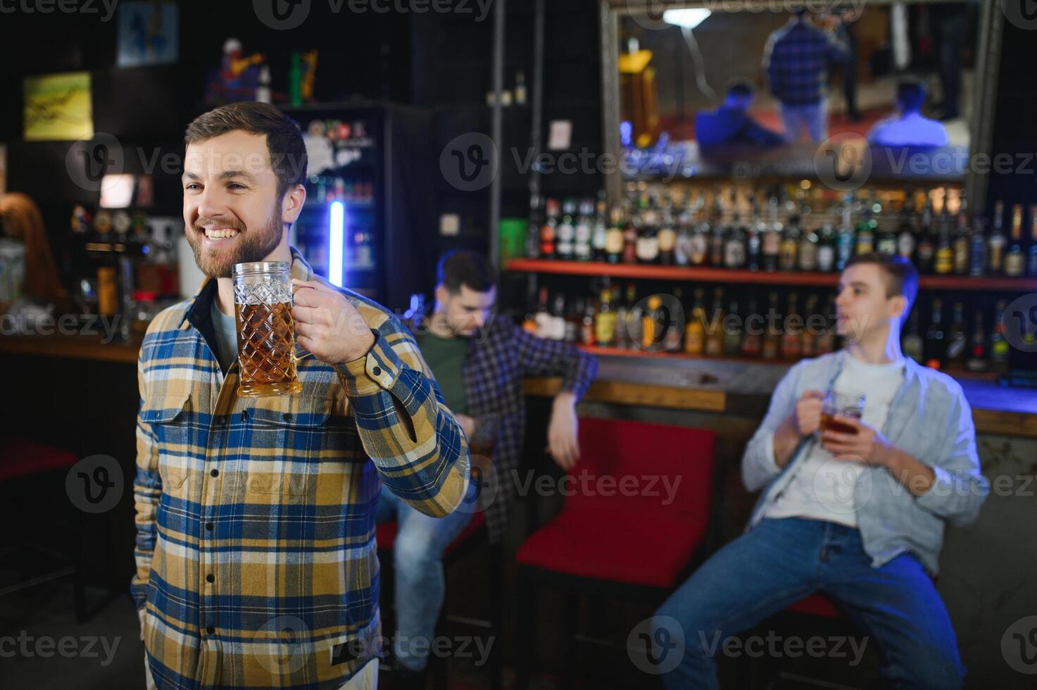 Handsome bearded man drinking beer at the bar counter in pub photo