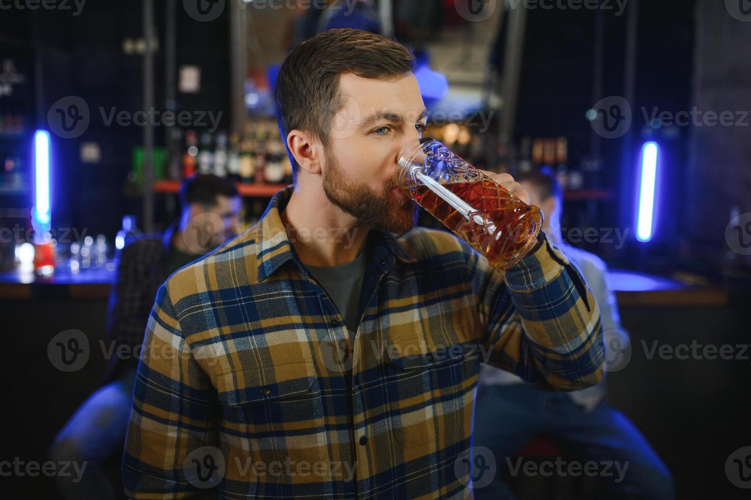 Tasting a good beer. Portrait of thoughtful men drinking beer at the bar photo