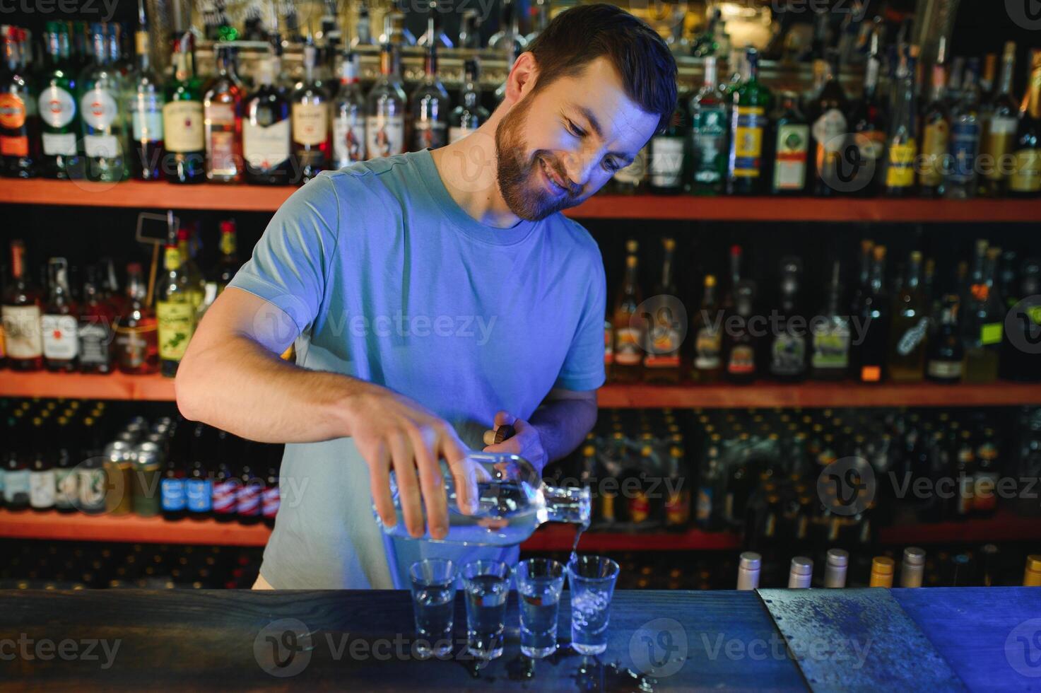 Handsome bar tender standing behind his counter in a pub photo