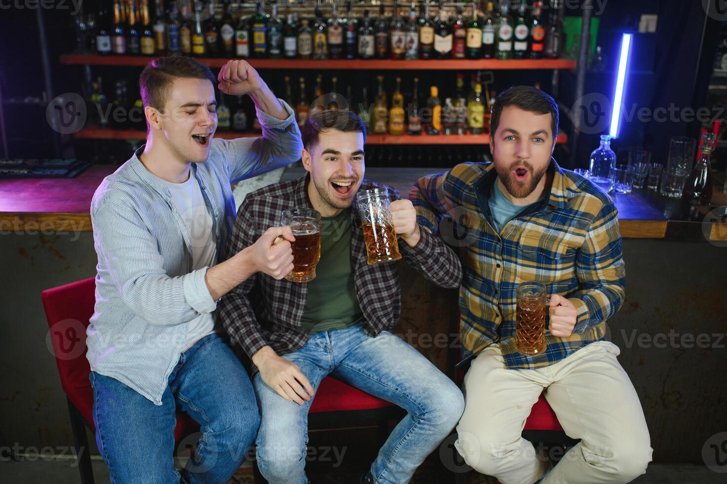 Sport, people, leisure, friendship, entertainment concept - happy male football fans or good yuong friends drinking beer, celebrating victory at bar or pub. Human positive emotions concept photo