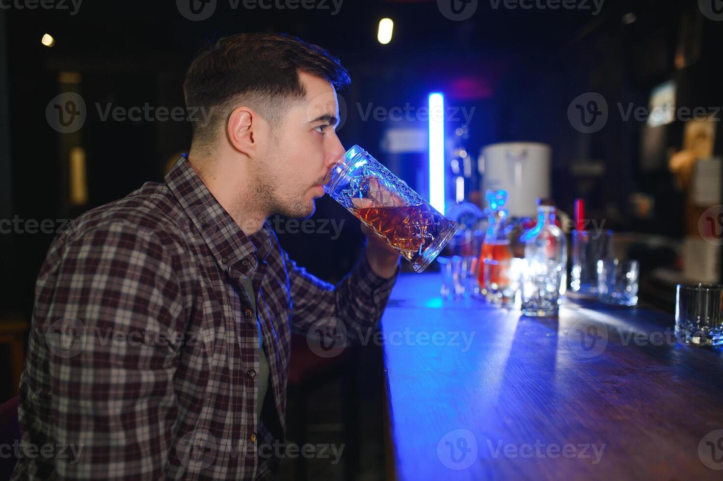 Night in bar. Portrait of cheerful men drinking beer at the bar photo