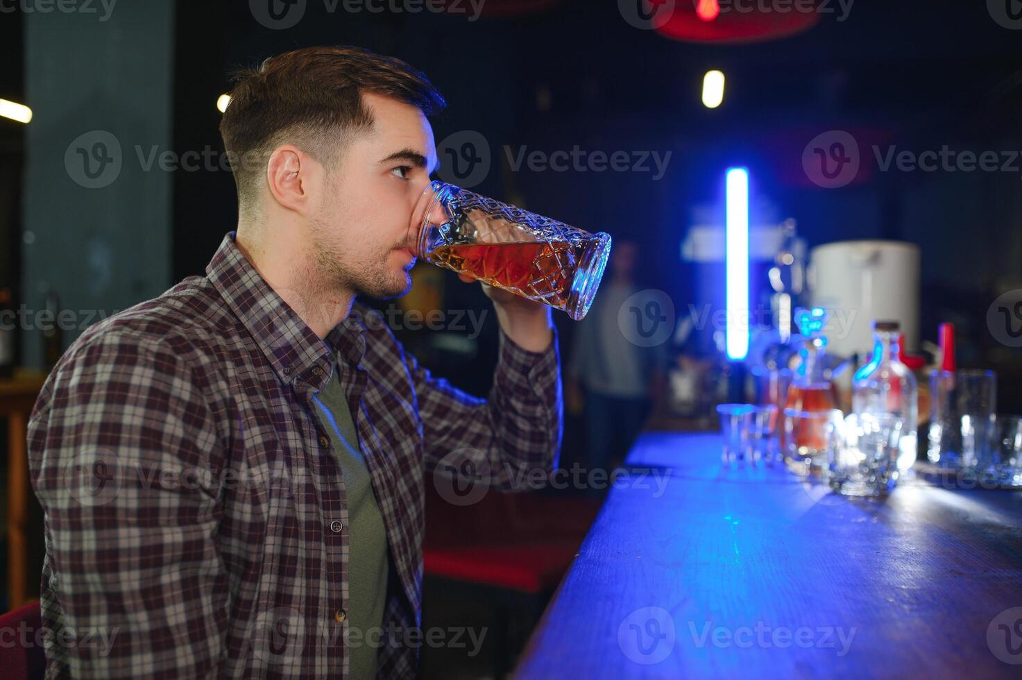 Night in bar. Portrait of cheerful men drinking beer at the bar photo
