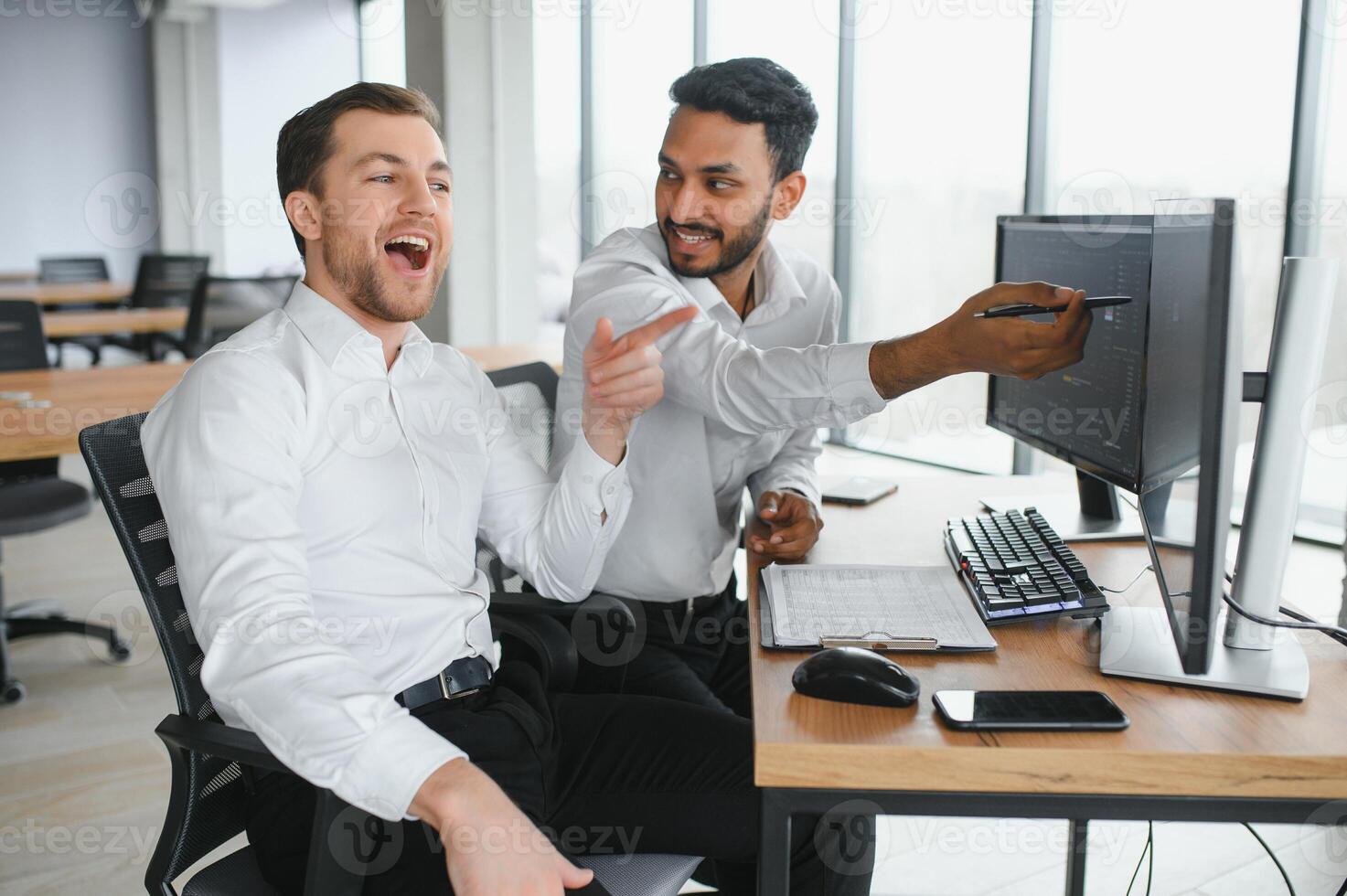 Two men traders sitting at desk at office together monitoring stocks data candle charts on screen analyzing price flow smiling cheerful having profit teamwork concept photo