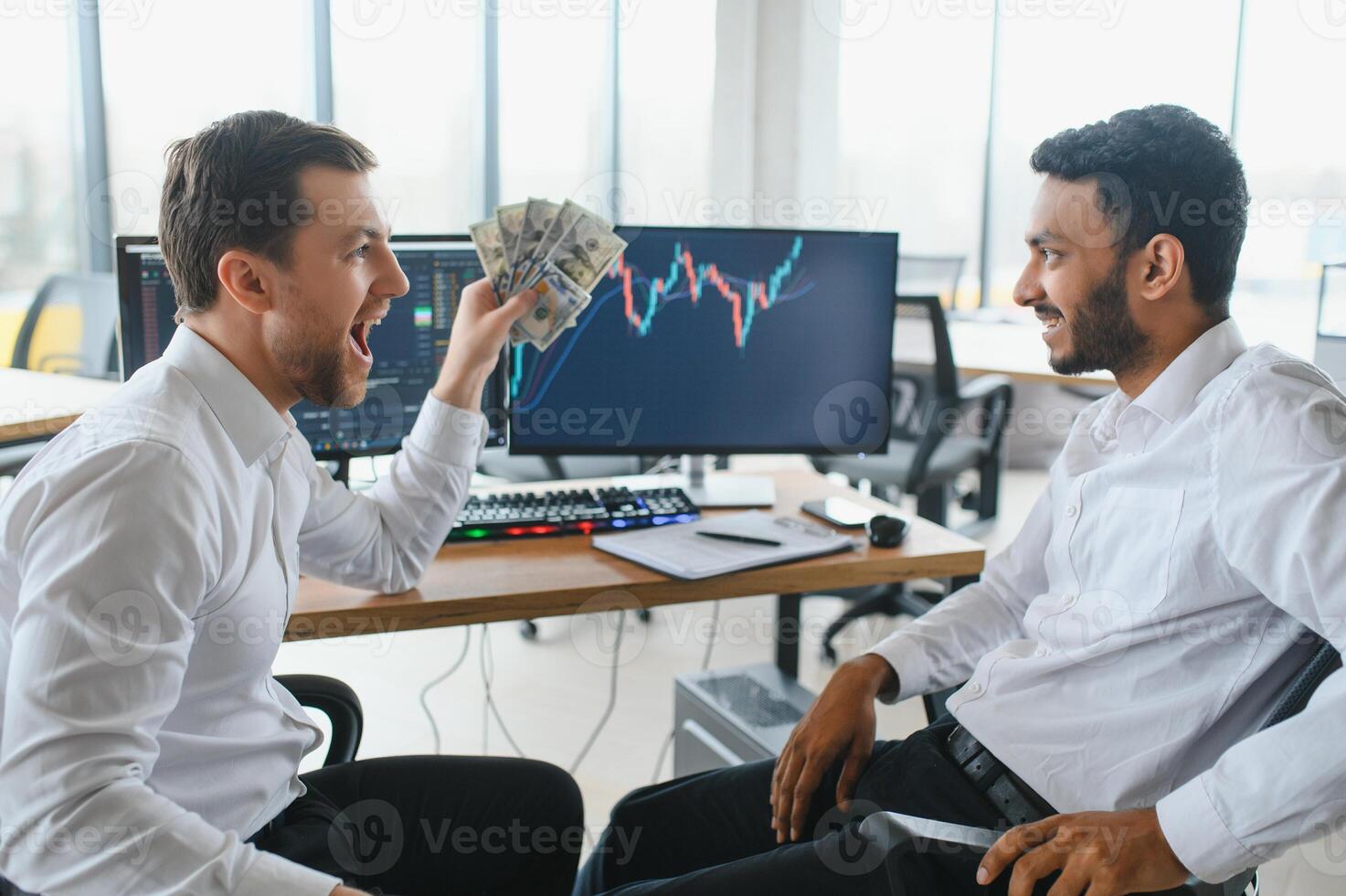 Two successful trader sitting in office and looking at screen, checking cryptocurrency information data on finance market graph, pointing on monitor photo