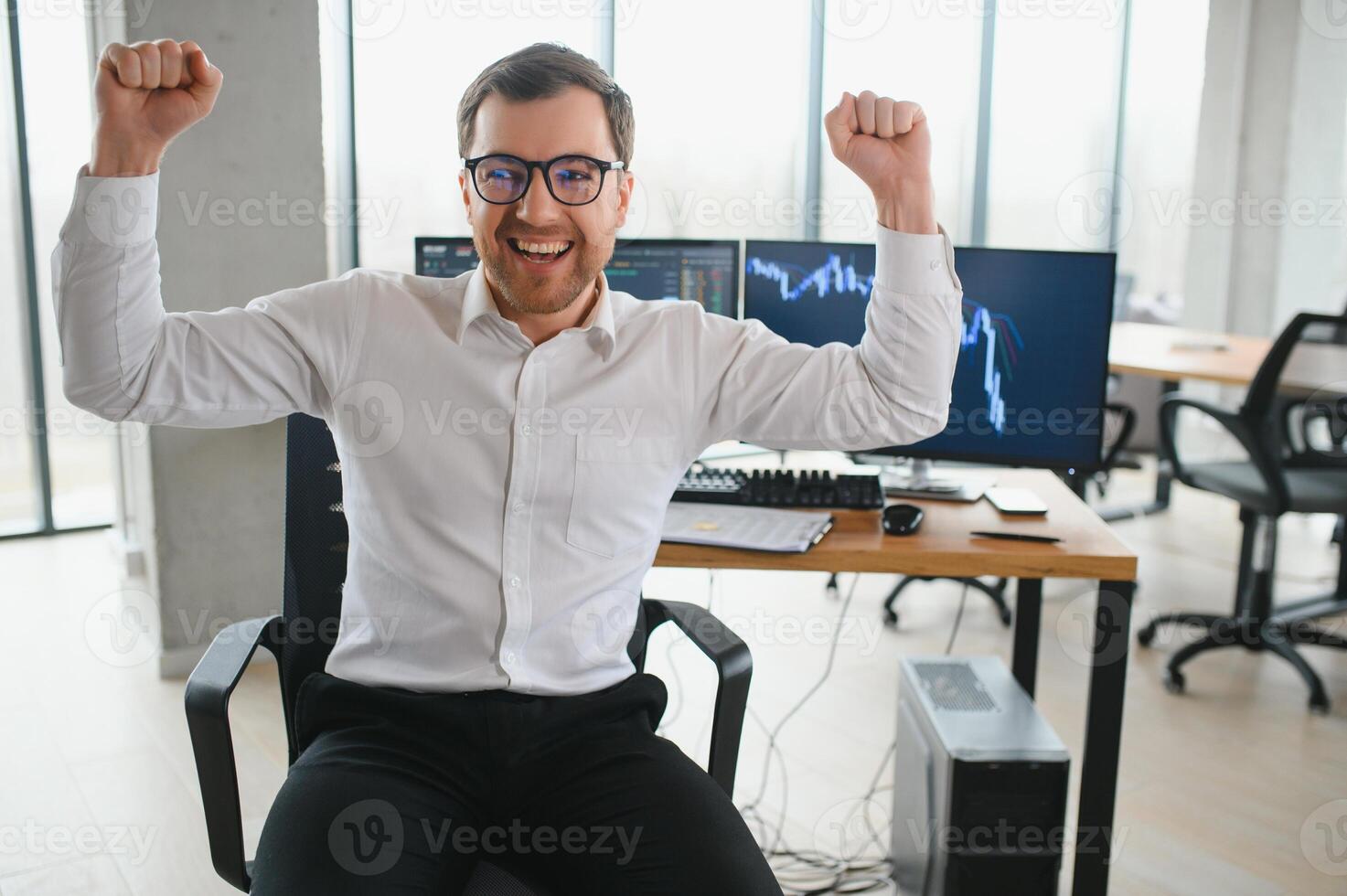 Man trader in formalwear sitting at desk in frot of monitors with charts and data at office browsing laptop checking documents analyzing stocks price changes concentrated. photo