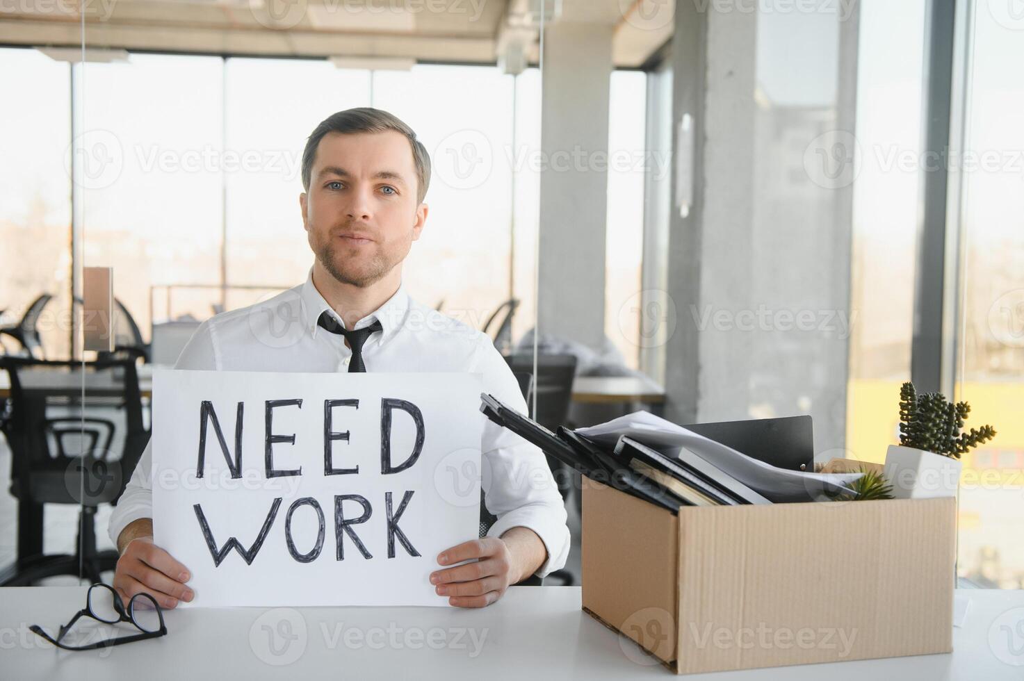 Sad Fired. Let Go Office Worker Packs His Belongings into Cardboard Box and Leaves Office. Workforce Reduction, Downsizing, Reorganization, Restructuring, Outsourcing. Mass Unemployment Market Crisis photo