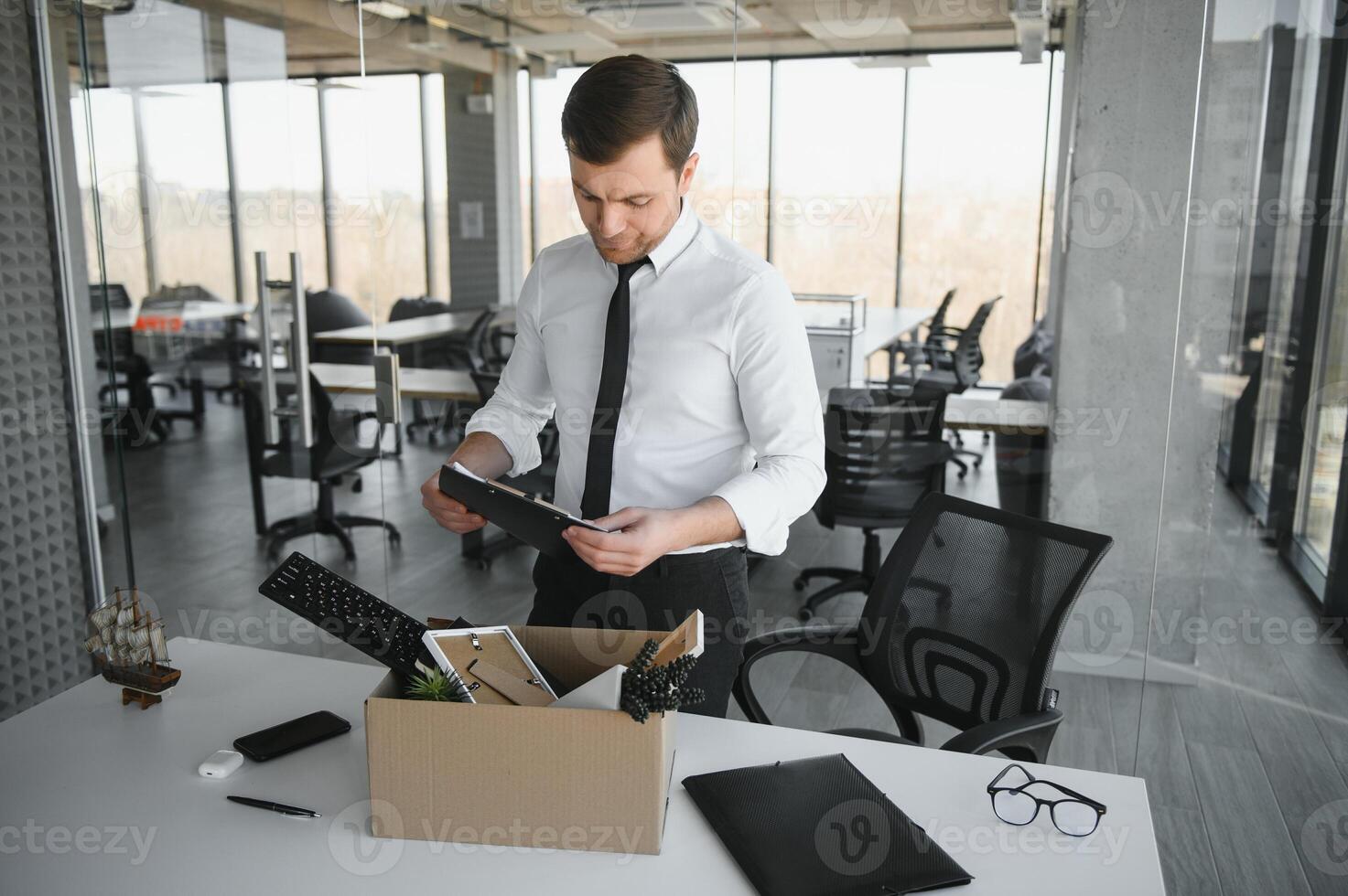 business, firing and job loss concept - fired male office worker with box of his personal stuff. photo
