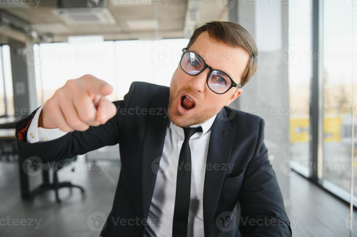 Angry senior businessman sitting at his desk and screaming photo