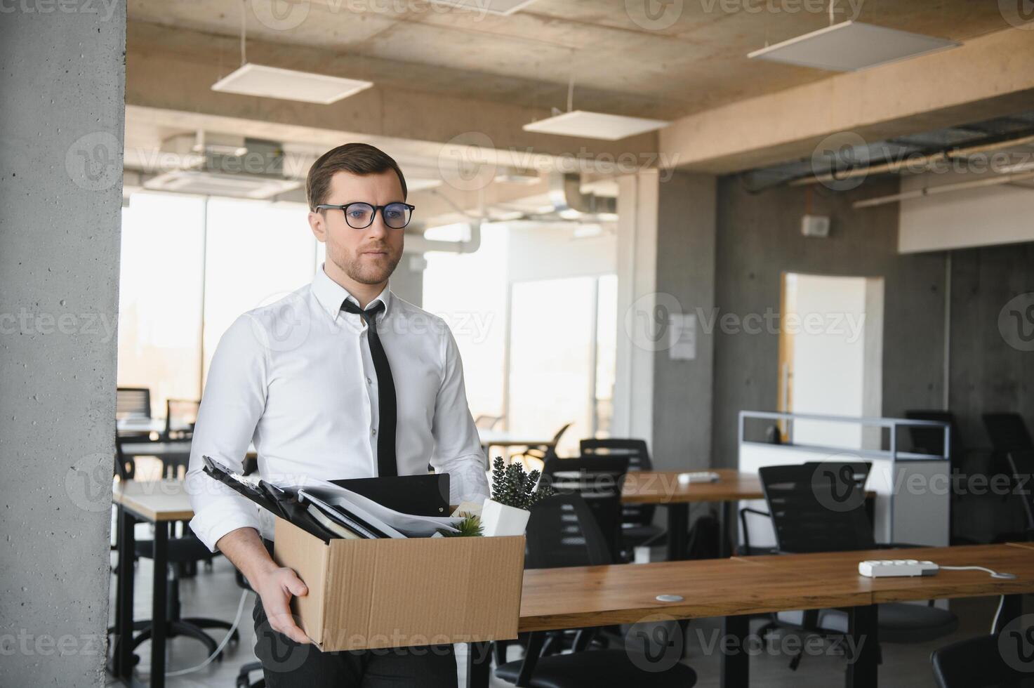 business, firing and job loss concept - fired male office worker with box of his personal stuff. photo