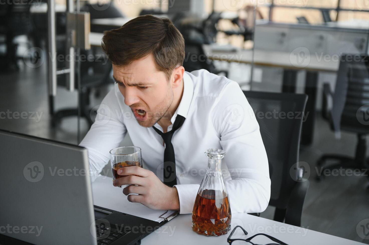 Alcoholism at work. Tired employee drinking alcohol at workplace, can not handle stress. photo