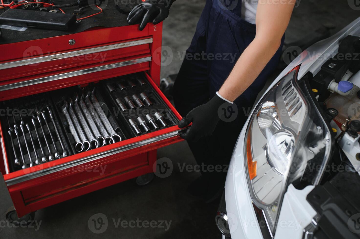 Auto mechanic working on car engine in mechanics garage. Repair service. photo