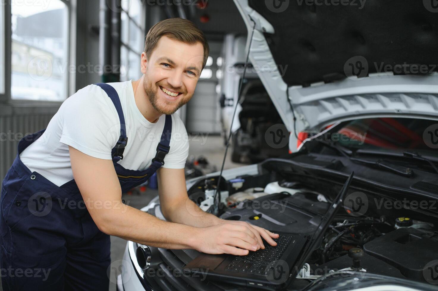 Auto service, repair, maintenance concept. mechanic checks the car, making diagnostics with laptop at the service station. Service maintenance of industrial to engine repair. photo