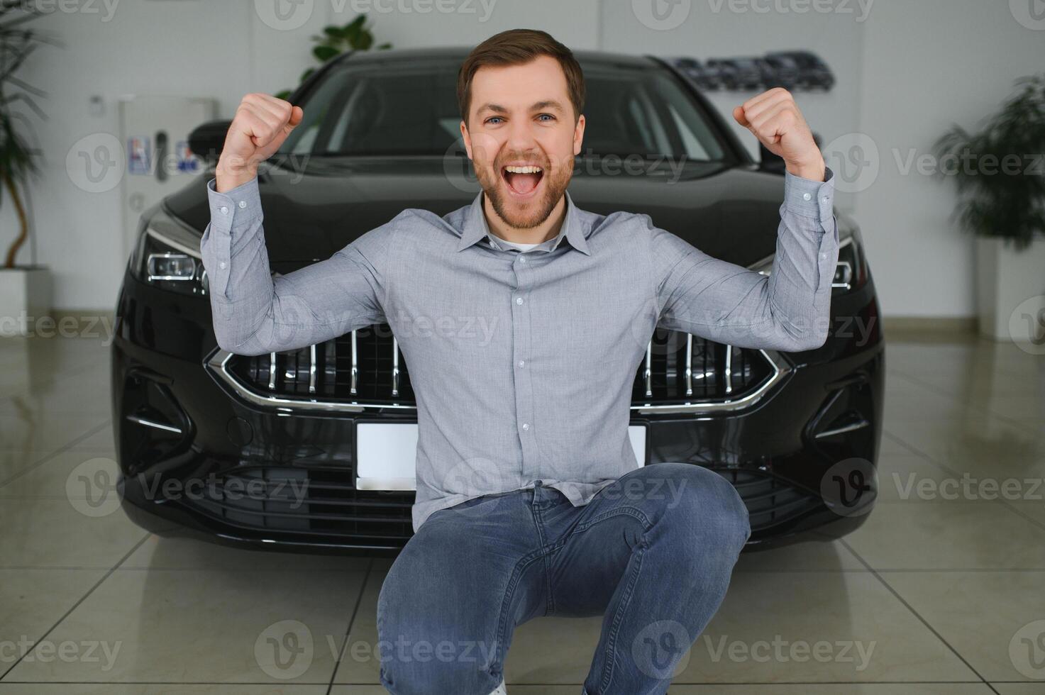 Young man is choosing a new vehicle in car dealership. photo