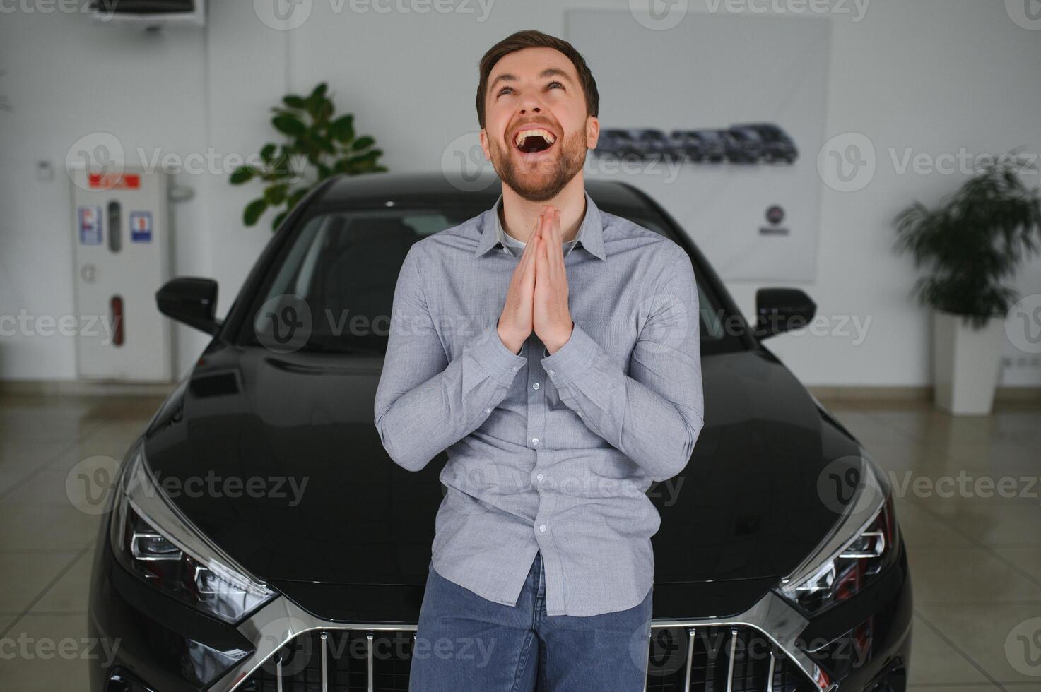 Young man is choosing a new vehicle in car dealership. photo