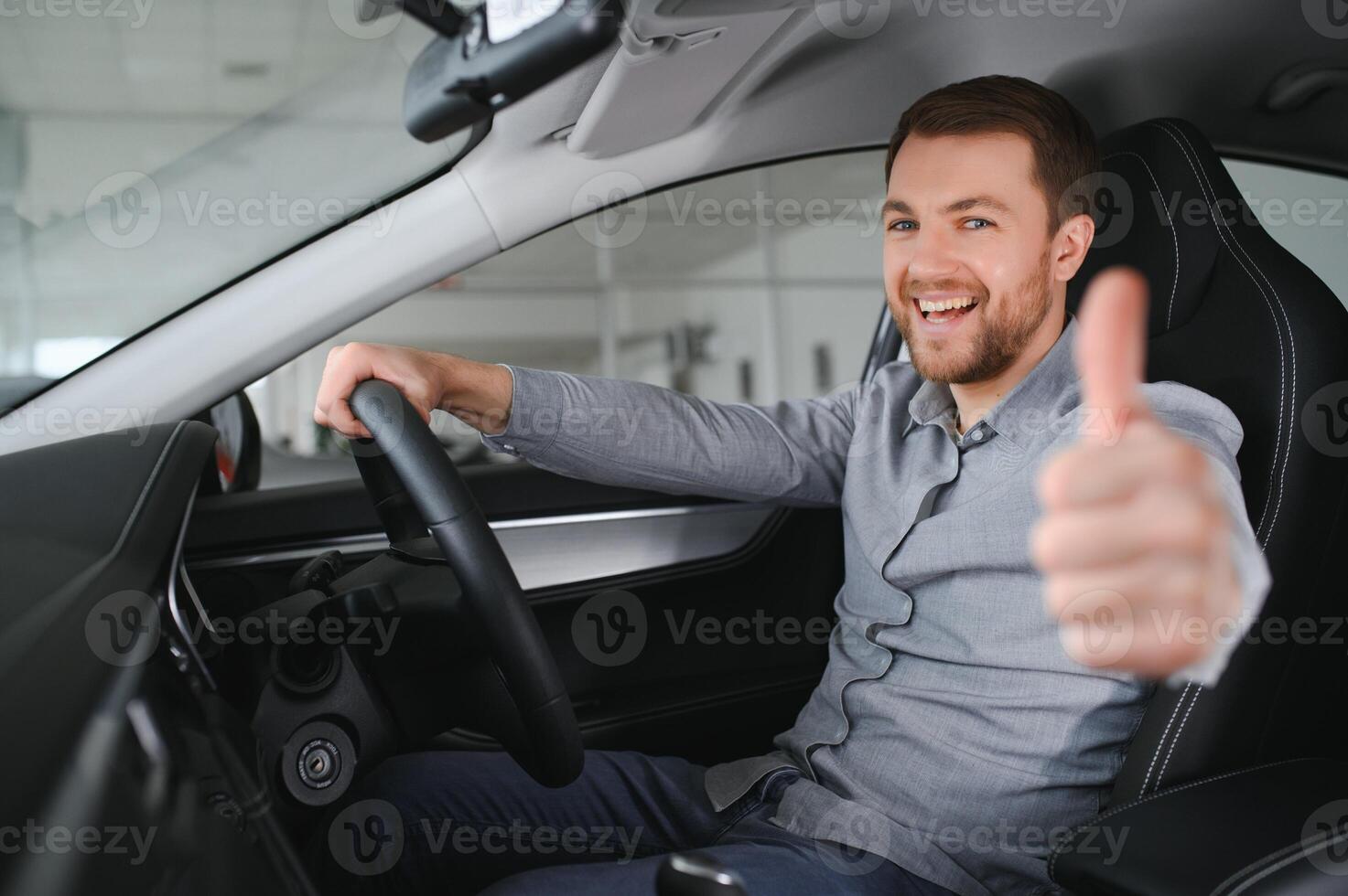Successful and happy. Shot of a happy mature man smiling to the camera sitting in his brand new car at the local dealership photo