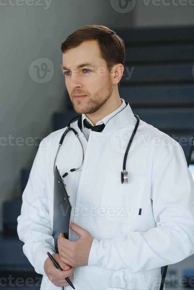 Portrait of smiling doctor in uniform standing in medicine clinic hall photo