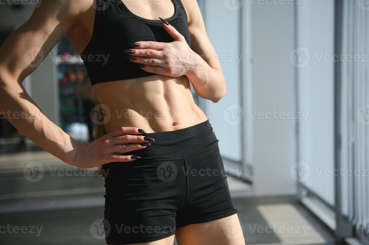 Fitness woman showing abs and flat belly. Athletic girl shaped abdominal photo