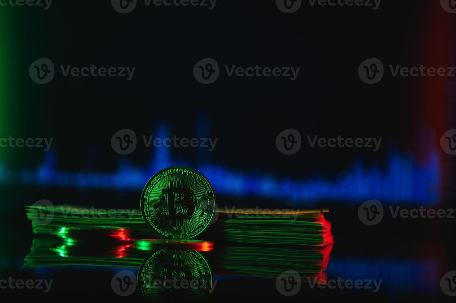 Golden bitcoin are stacked on a bright background of business graphs close-up. Bitcoin cryptocurrency. Folded in a tube 100 dollar bills photo