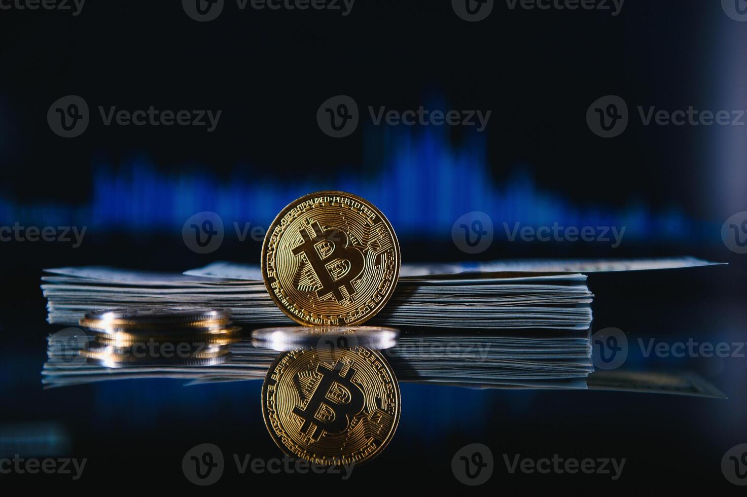 Golden bitcoin are stacked on a bright background of business graphs close-up. Bitcoin cryptocurrency. Folded in a tube 100 dollar bills photo