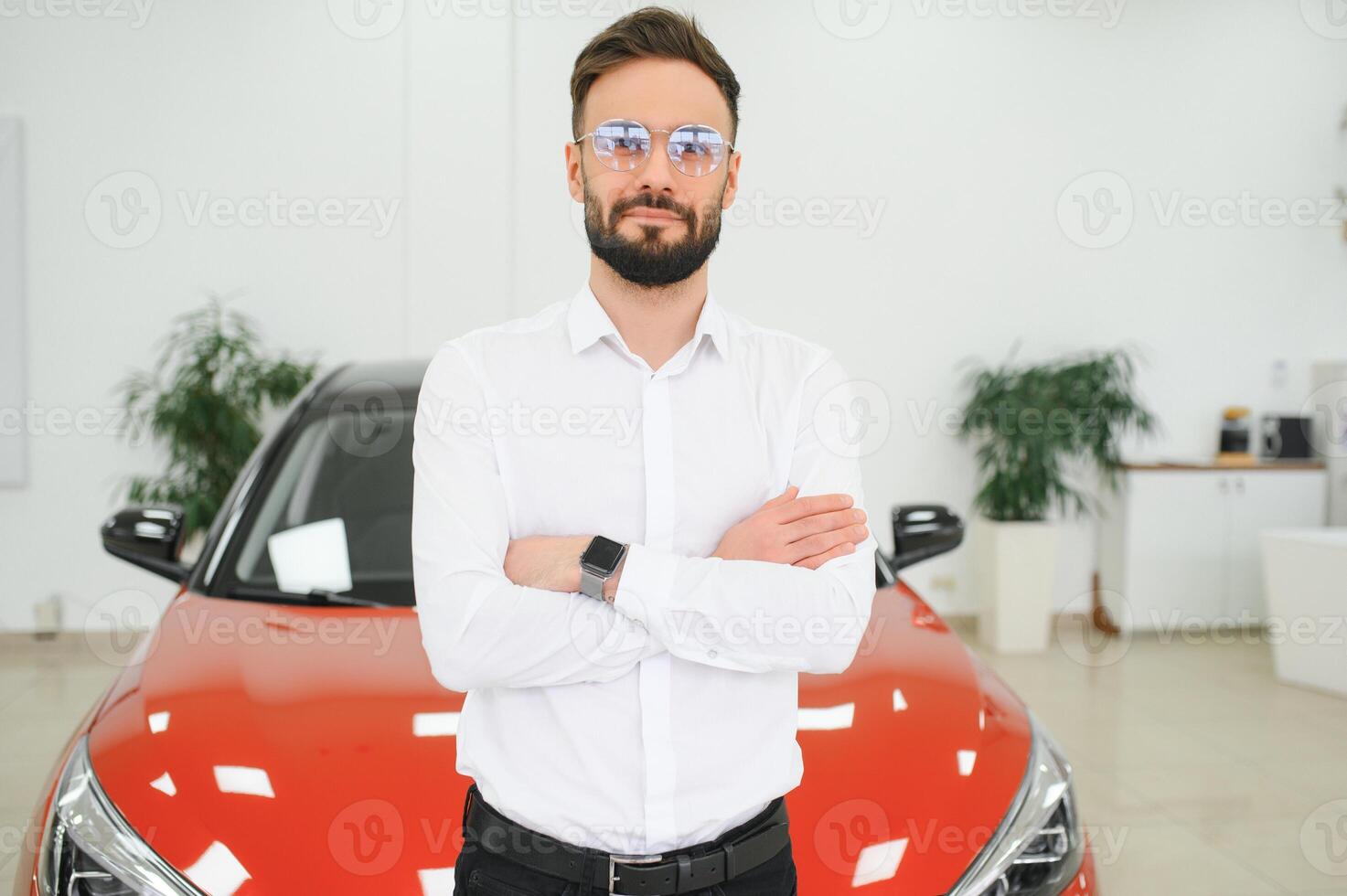 Happy young guy checking new luxury car, buying automobile at dealership centre. Portrait of cheerful millennial Caucasian man examining auto at showroom store photo