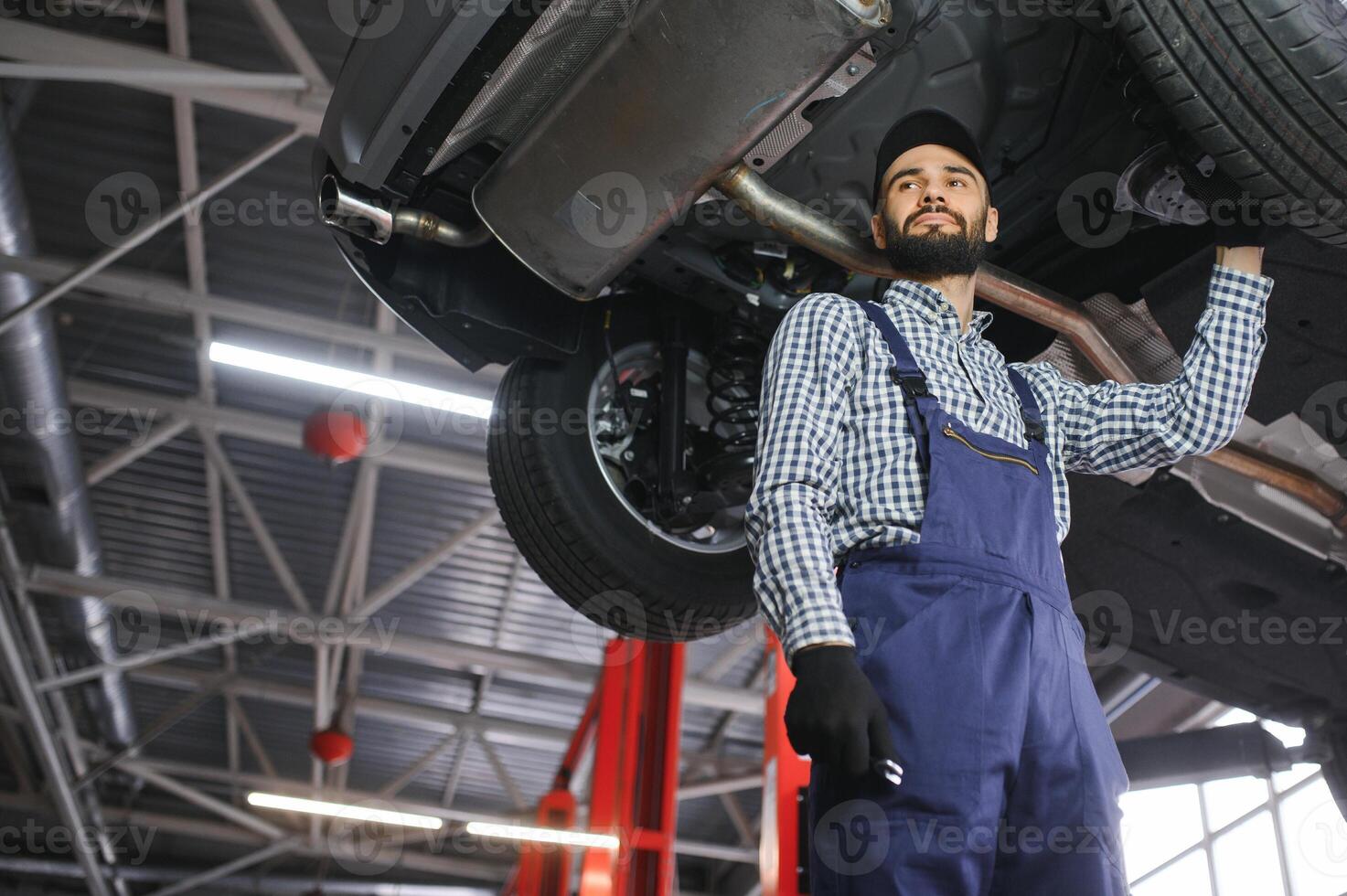 Auto mechanic working at auto repair shop photo