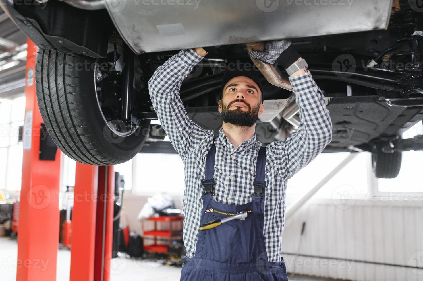 Auto mechanic working at auto repair shop photo