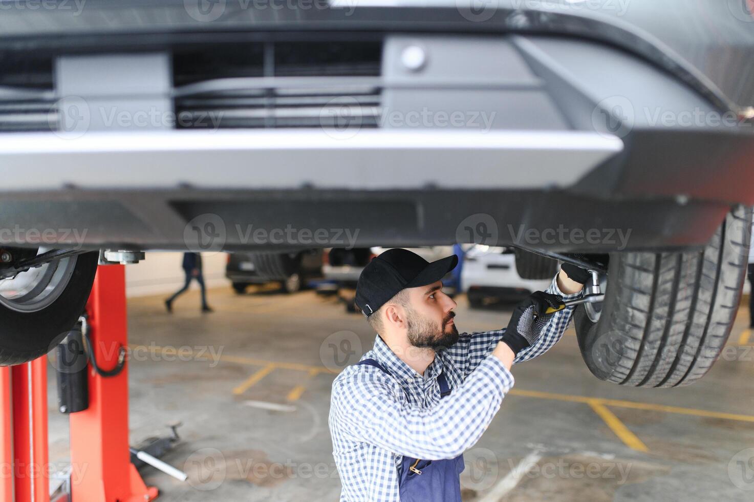 Auto mechanic working at auto repair shop photo
